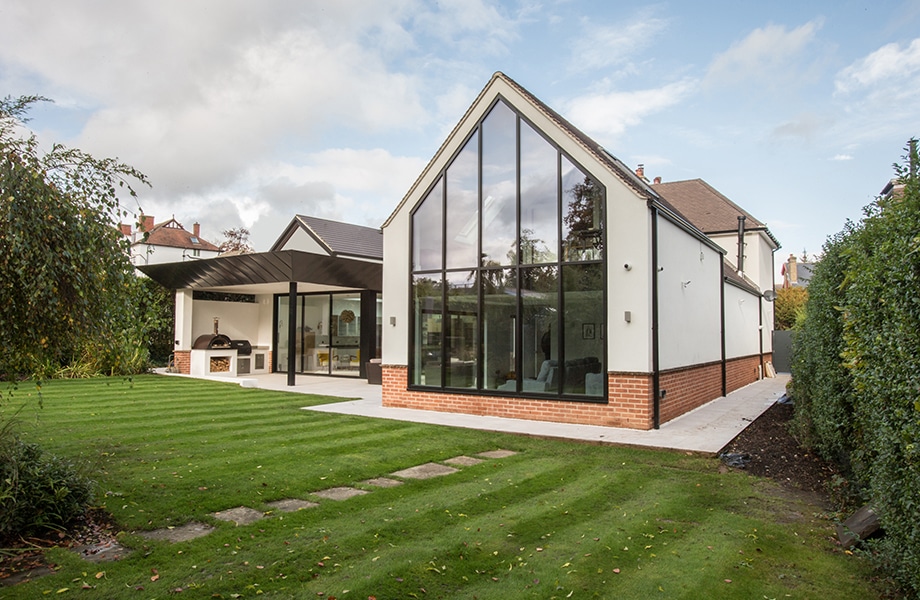 Modern house extension with large aluminium glazing system, bifold doors and floor-to-ceiling windows installed by builder.