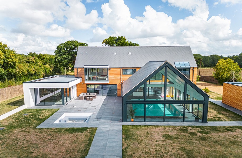 Modern high-end residential development featuring aluminium glazing systems including bifold doors, sliding glass panels, and structural glazing throughout.