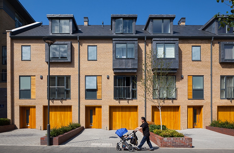 Modern brick townhouses with yellow garage doors and aluminium glazing systems installed by regional developer partner.